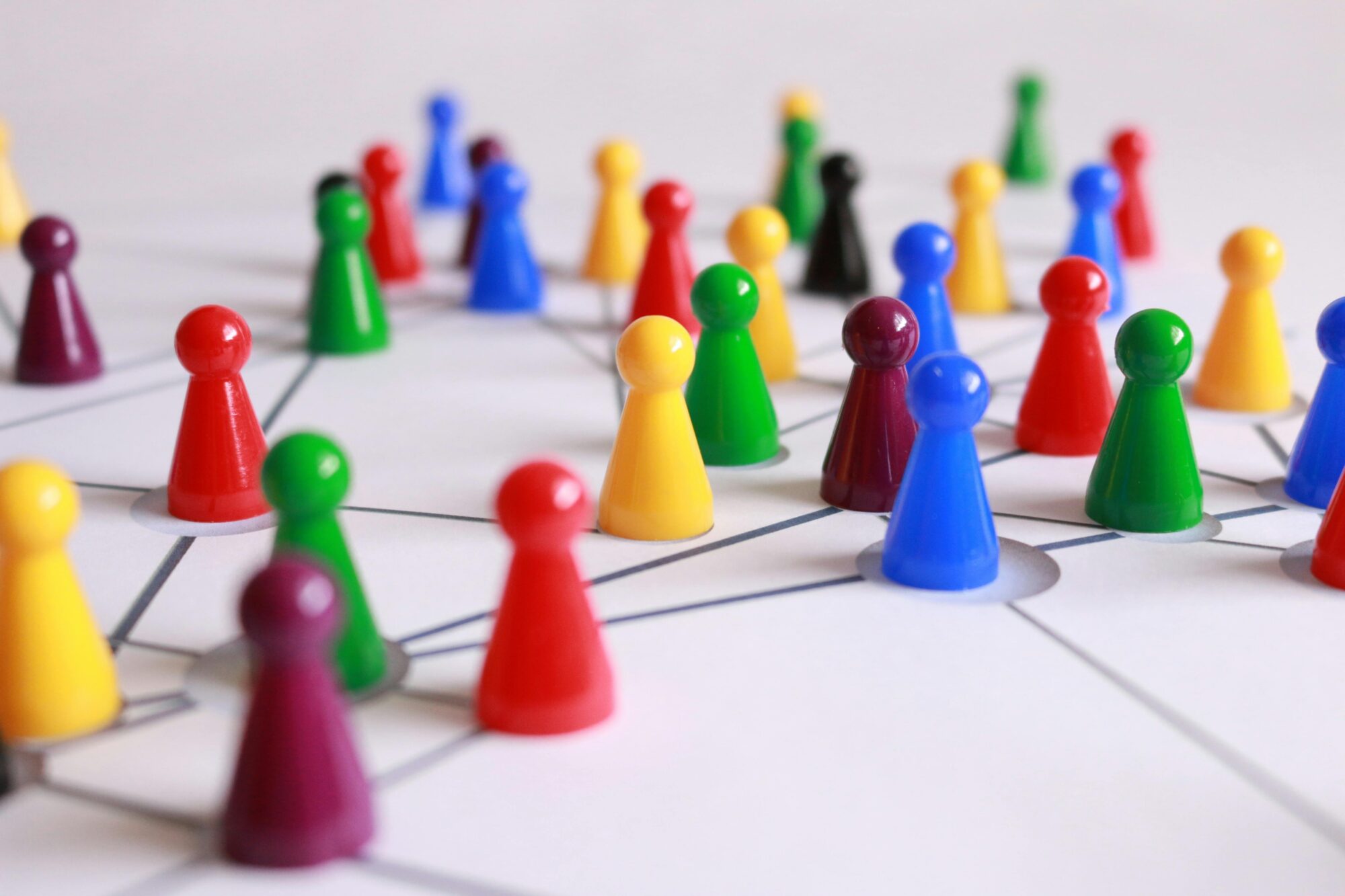 Colorful game pieces connected by lines on a whiteboard, symbolizing teamwork and collaboration.